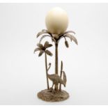 A plated table centrepiece in the form of two entwined palm trees with ostrich below