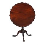 A carved mahogany tilt top occasional table