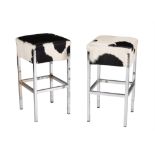 A pair of cow hide upholstered chrome bar stools