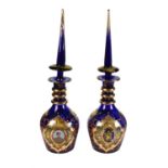 A pair of Turkish blue glass enamelled and gilt large decanters and stoppers printed with portraits
