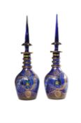 A pair of modern Turkish blue glass, enamelled and gilt large decanters and spire stoppers