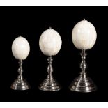 A graduated set of three bone 'eggs' on nickel plated stands by Anthony Redmile