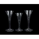 Three plain stemmed wine glasses of drawn trumpet form