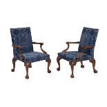 A pair of walnut and upholstered open armchairs