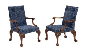 A pair of walnut and upholstered open armchairs