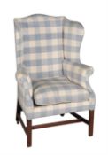 A George III mahogany and upholstered wing armchair