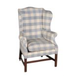 A George III mahogany and upholstered wing armchair