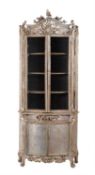 A Continental carved and silver painted display cabinet