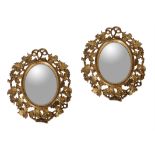 A pair of small carved giltwood oval wall mirrors