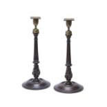 A pair of late George III turned mahogany and brass mounted candlesticks
