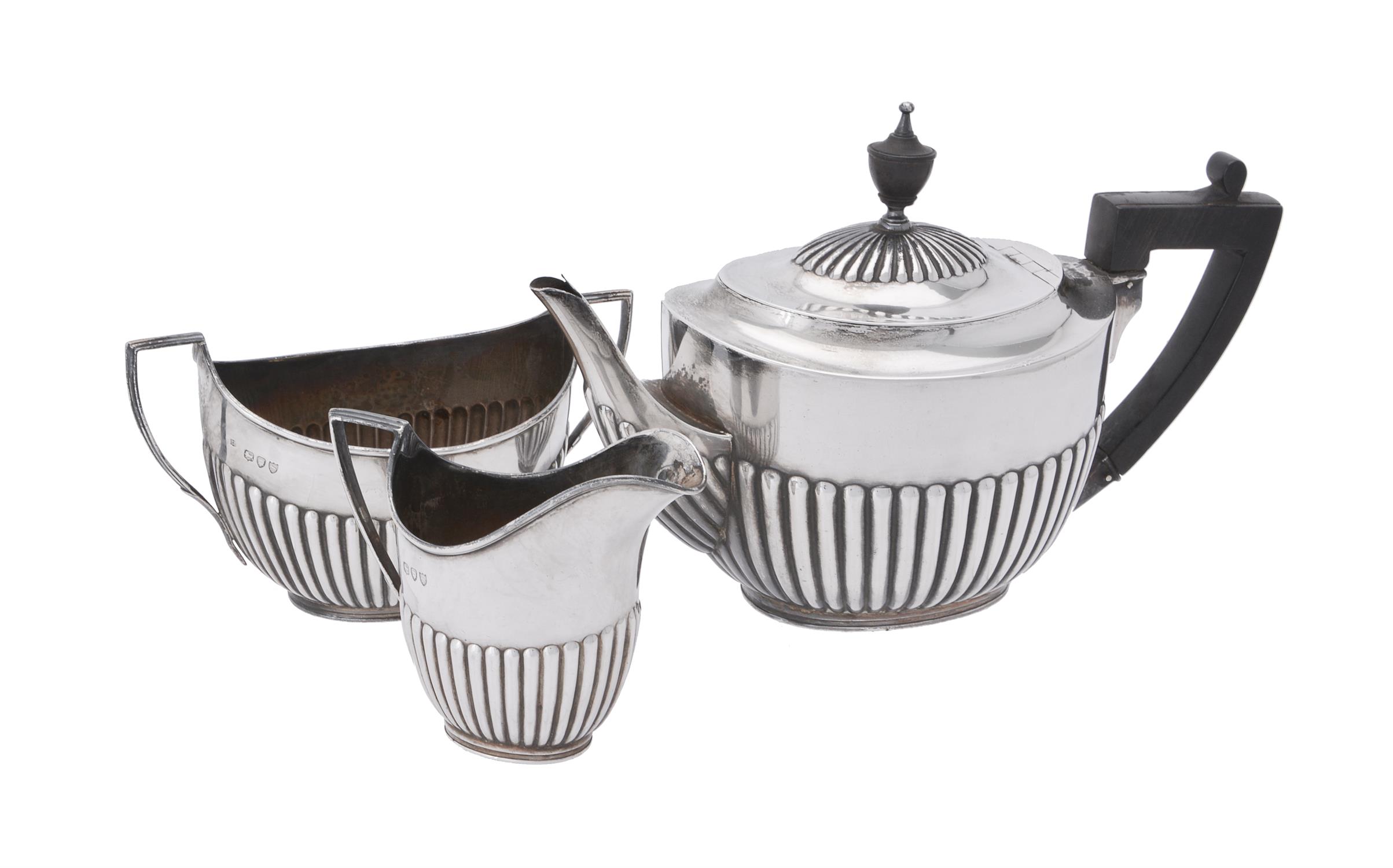 A Victorian silver three piece oval half gadrooned tea set by William Hutton & Sons