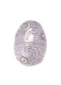 A silver coloured egg shaped nutmeg grater