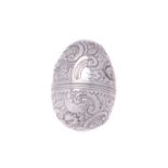 A silver coloured egg shaped nutmeg grater