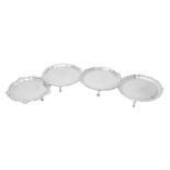Four silver shaped circular waiters