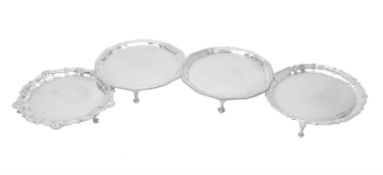 Four silver shaped circular waiters