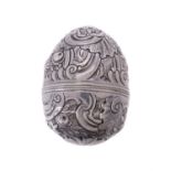A silver coloured egg shaped nutmeg grater