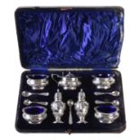 A late Victorian silver seven piece cruet set by Walker & Hall