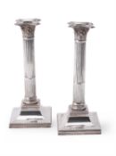 An Edwardian pair of silver Corinthian column candlesticks by Hawksworth, Eyre & Co. Ltd.
