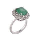 An emerald and diamond cluster ring