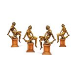A set of four German gilt bronze alloy models of seated youths