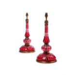 A pair of French cut cranberry glass and gilt metal mounted table lamps