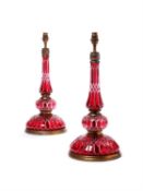 A pair of French cut cranberry glass and gilt metal mounted table lamps