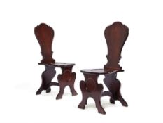 A pair of George II mahogany hall chairs