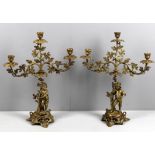 A pair of late 19th century French gilt bronze and brass figural three light candlesticks
