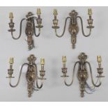 A set of four gilt metal twin light wall appliques