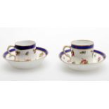 A pair of later decorated Sevres coffee cups and saucers