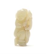 A Chinese pale celadon carving of a boy holding a Lotus Stalk