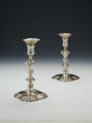 A pair of late George II cast silver shaped square candlesticks by John Perry