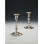 A pair of late George II cast silver shaped square candlesticks by John Perry