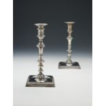 A pair of George III cast silver square candlesticks