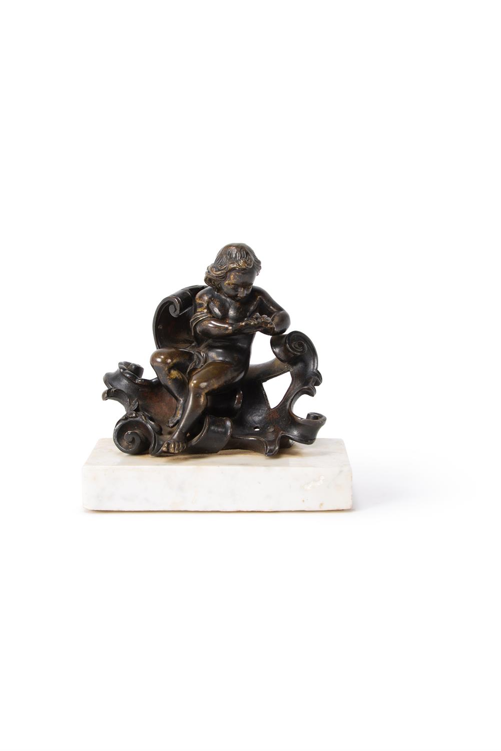 A gilt bronze model of a putto warming his hands