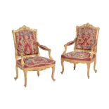 A pair of carved giltwood open armchairs