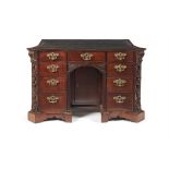 A George II mahogany serpentine kneehole desk