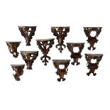 A companion set of ten unusual carved walnut miniature wall brackets