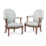 A matched pair of George III mahogany and upholstered open armchairs