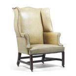A George II mahogany and leather upholstered wing armchair