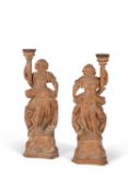A pair of German or Austrian carved limewood figural candlesticks, 18th century