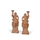 A pair of German or Austrian carved limewood figural candlesticks, 18th century