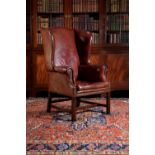 A mahogany and red leather upholstered wing armchair