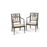 A pair of George III ebonised and painted open armchairs