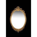 A Victorian carved giltwood and composition oval wall mirror by J & W Vokins