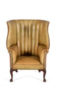 A George II mahogany and leather upholstered 'barrel' back wing armchair