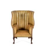 A George II mahogany and leather upholstered 'barrel' back wing armchair