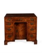 A George II figured walnut and crossbanded kneehole desk