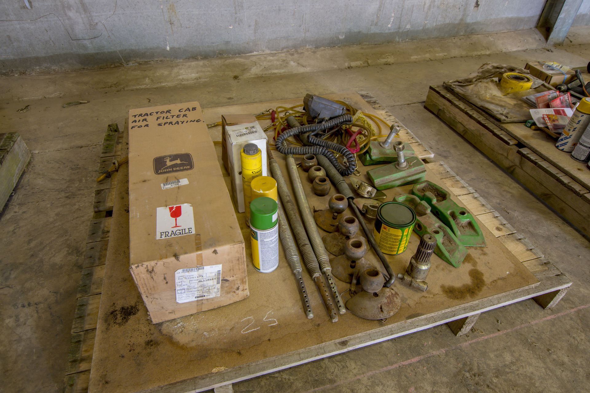 Pallet of assorted John Deere tractor attachments.