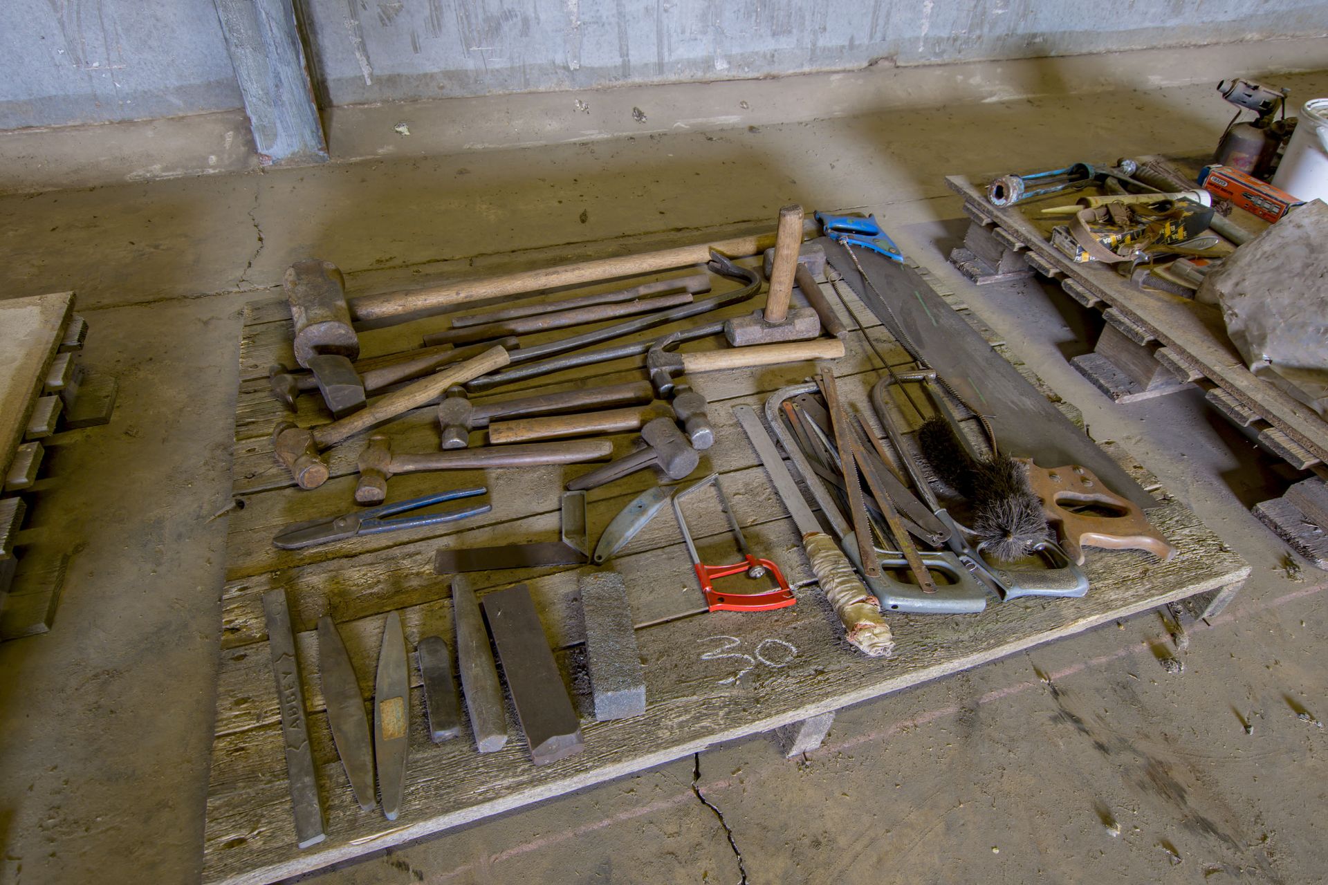 Pallet of assorted tools to include whet stones, hammers, saws and 14lb hammer.